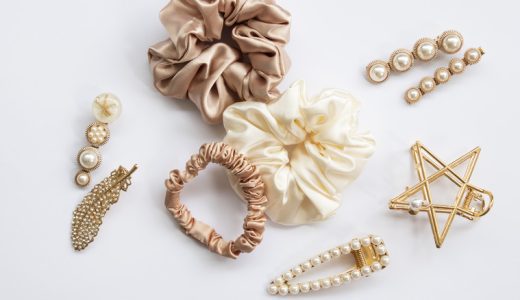 Collection of trendy silk elastic band scrunchies and pearl hair clips on white background. Diy accessories and hairstyles concept, luxury color